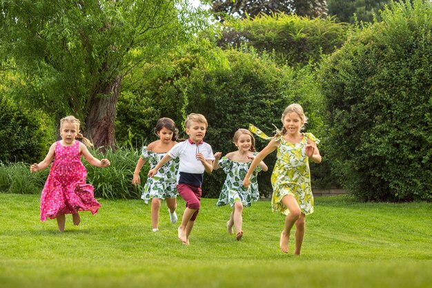 Grappig begint. Kindermode concept. groep tienerjongens en meisjes die bij park lopen