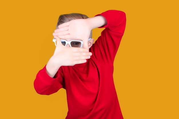 Grappig kind met een 3d-filmbril houdt zijn handen bij elkaar en kijkt erdoorheen