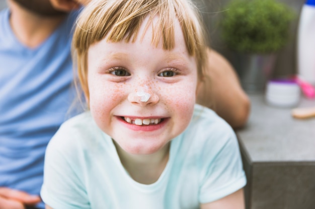 Gratis foto grappig meisje met crème op neus