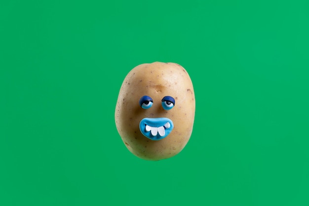 Gratis foto grappige aardappel met gezichtssticker