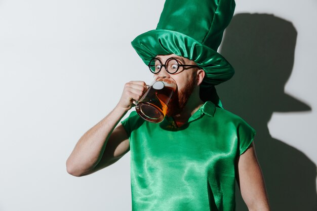 Grappige dronken man in st.patriks kostuum bier drinken