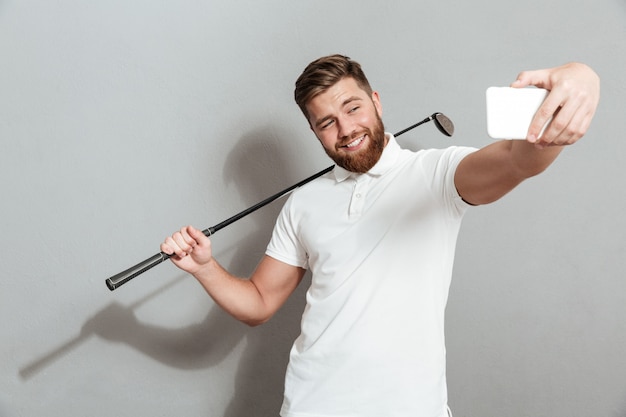 Grappige gelukkig golfer selfie maken op zijn smartphone