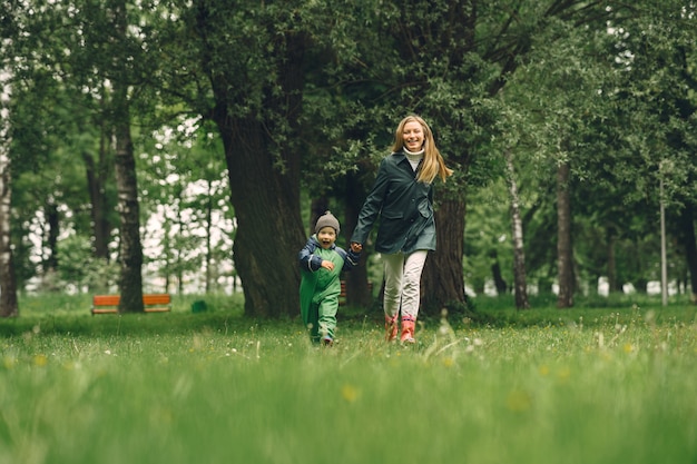 Grappige jongen in regenlaarzen spelen in een regenpark