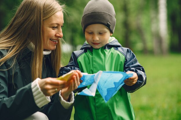 Grappige jongen in regenlaarzen spelen in een regenpark