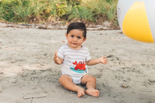 Grappige jongen spelen op het strand