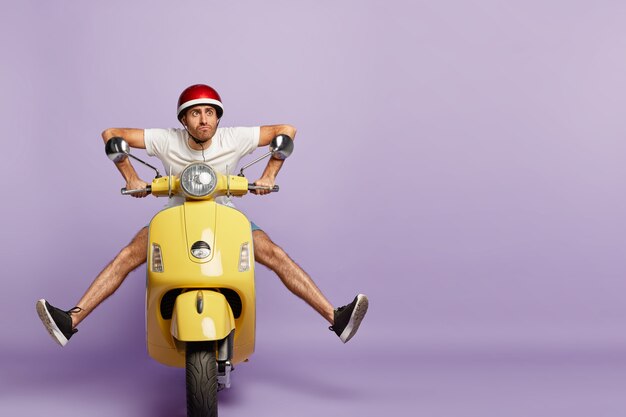 grappige kerel met helm gele scooter rijden