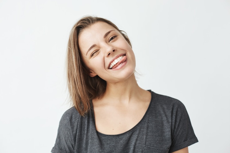 Gratis Foto grappige schattig jong meisje glimlachend knipogen weergegeven: tong.