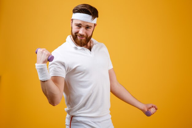 Grappige sportman die oefening met lichtgewicht domoren doet