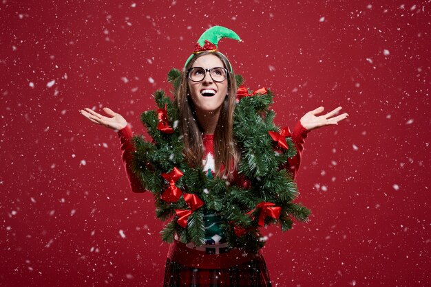 Gratis foto grappige vrouw met kerstmisslinger in de sneeuw