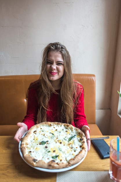 Gratis foto grappige vrouw toont haar pizza