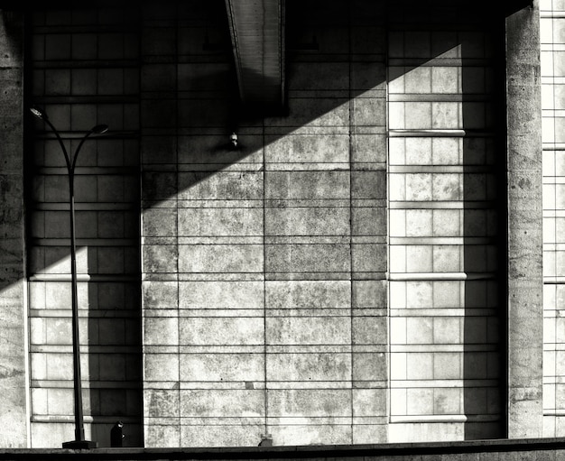 Grayscale symmetrisch schot van een steen in de schaduw gestelde muur - depressie, eenzaamheidconcept