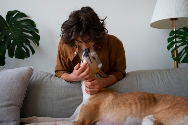 Greyhound hond met mannelijke eigenaar thuis op de bank