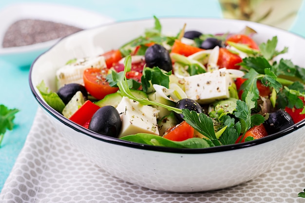 Griekse salade met komkommer, tomaat, paprika, sla, groene ui, fetakaas en olijven met olijfolie. Gezond eten.