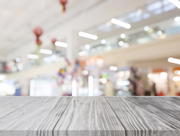 Grijs houten bureau voor verlicht winkelcentrum