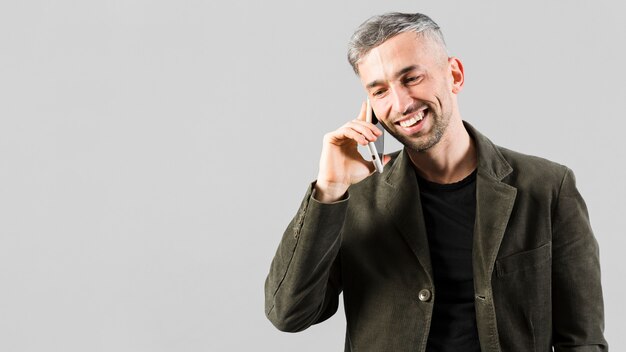 Grijsharig mannetje dat op de telefoon spreekt en exemplaarruimte