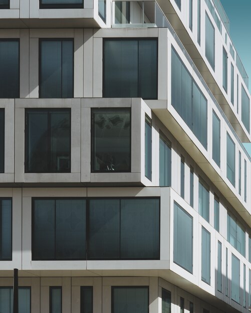 grijze betonnen gebouw met grote ramen onder de blauwe hemel