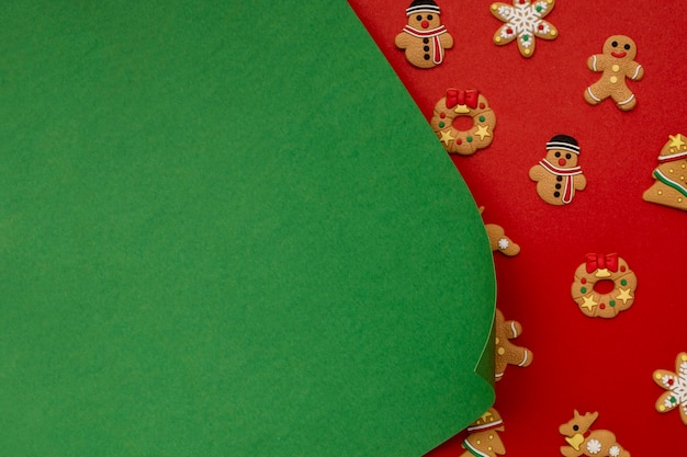 Gratis foto groenboek en kerstkoekjes op rode tafel