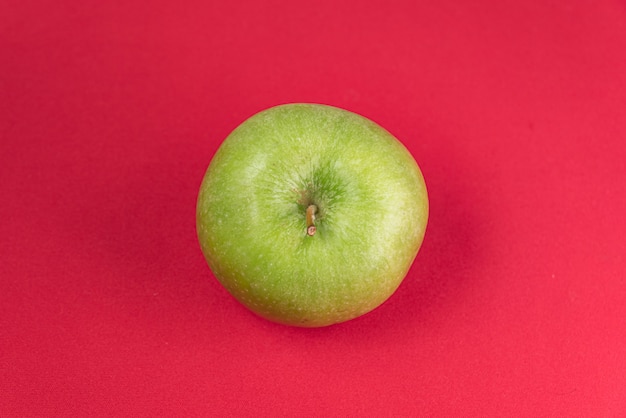 Groene appel op de rode achtergrond