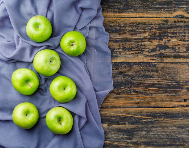 Groene appels bovenaanzicht op houten en textiel achtergrond