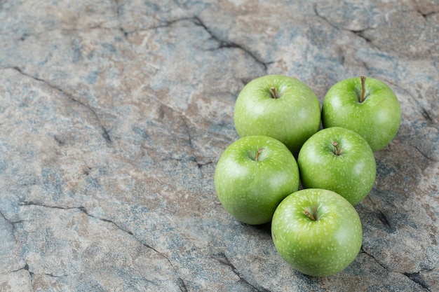 Groene appels geïsoleerd op grijs marmer.