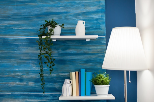 Groene bloemen op witte plank in blauwe kamer