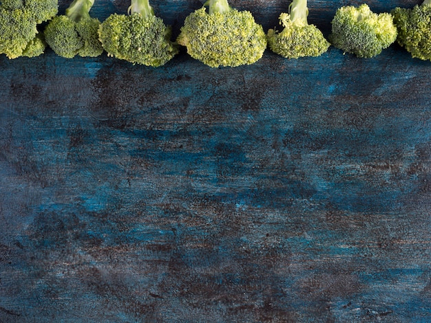 Gratis foto groene broccoli verspreid op tafel