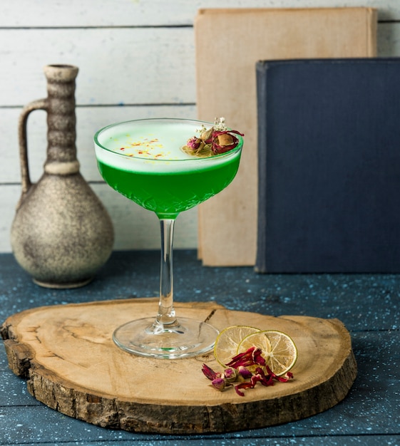 Groene cocktail met bloemen op de tafel