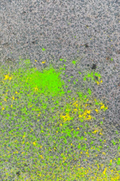 Groene en gele vlekken van verf op grungy asfalt