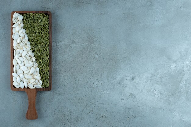 Groene en witte pompoenpitten op blauwe achtergrond. Hoge kwaliteit foto