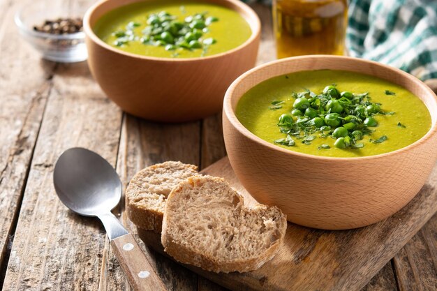Groene erwtensoep in een kom op een rustieke houten tafel