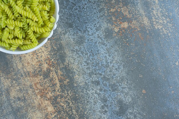 Groene fusilli pasta, op de marmeren achtergrond.