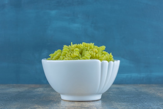 Groene fusilli pasta, op het marmeren oppervlak.