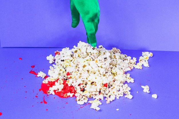 Groene hand aan het raken van popcorn