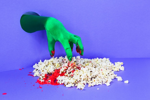 Groene hand die popcorn bereikt