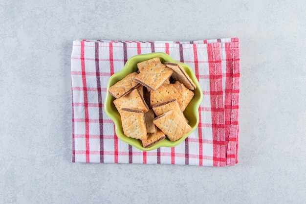 Groene kom smakelijke knapperige crackers op stenen achtergrond.