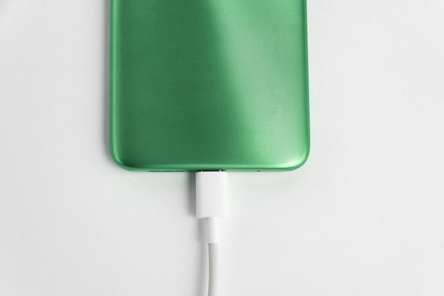 Gratis foto groene mobiele telefoon aangesloten op usb-kabel type c - opladen