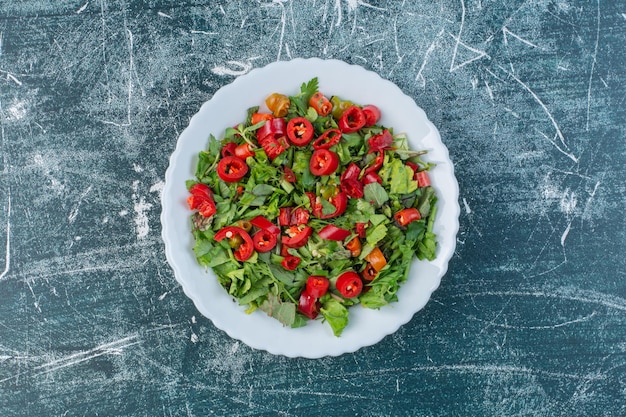 Groene salade met gehakte rode chilipepers.