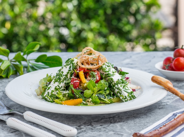 Groene salade met kruiden en tomaat.