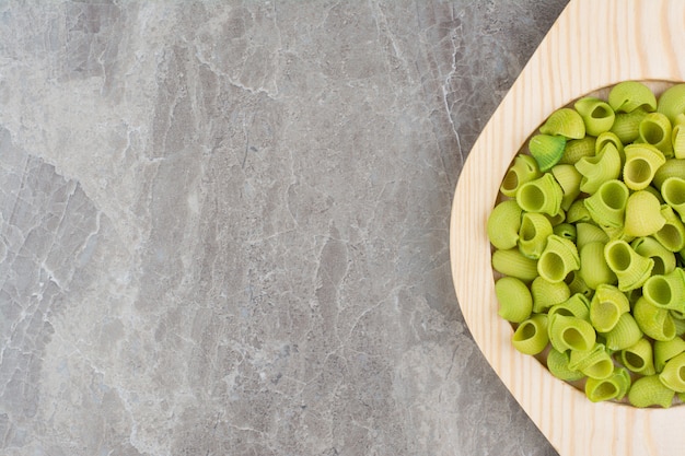 Groene zelfgemaakte pasta's in platen op de grijze ruimte.