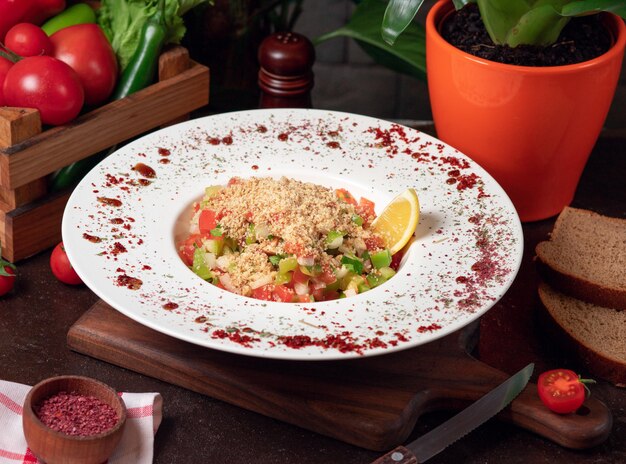 Groente, tomaten, komkommersalade met crackers. salade op de keukentafel in witte plaat