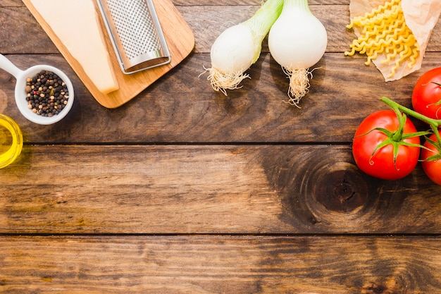 Gratis foto groenten en kaas in de buurt van pasta en kruiden