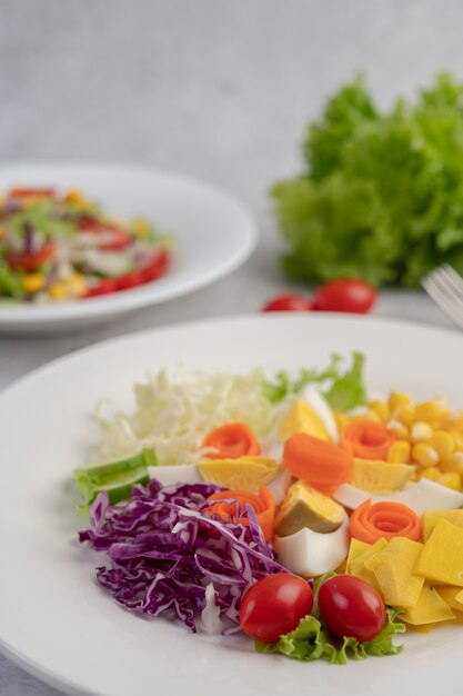 Groentesalade met gekookte eieren in een witte schotel.