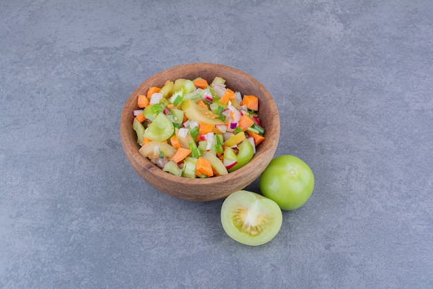 Groentesalade met seizoensgerechten in een houten schaaltje