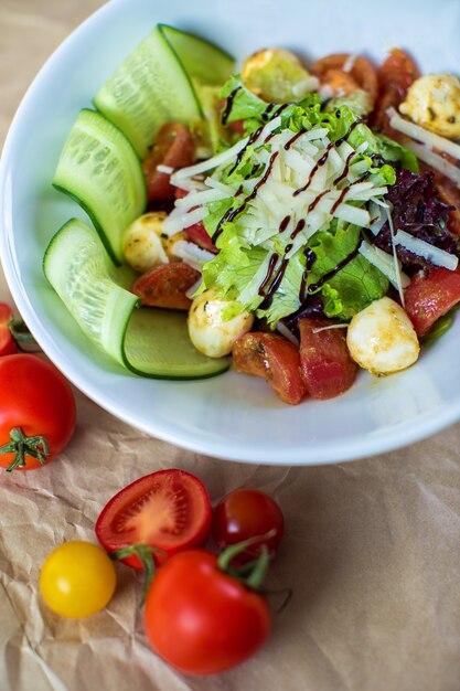 Groentesalade met sla, gekookte tomaat, komkommer en champignon met geraspte kaas