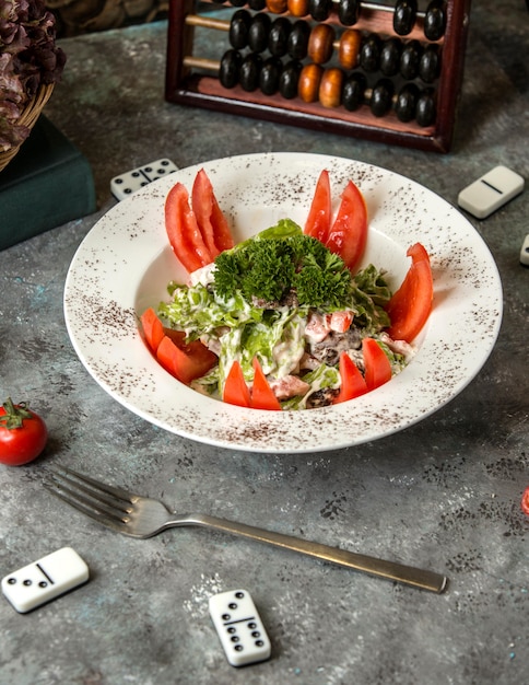 Groentesalade onder saus met tomaten