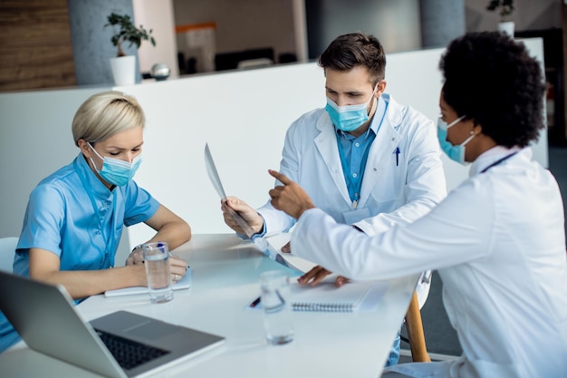 Groep artsen die samenwerken tijdens het analyseren van Xray in de medische kliniek