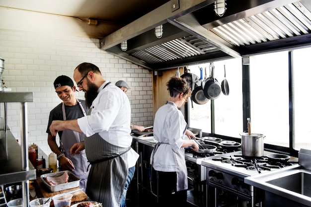 Groep chef-koks die in de keuken werken