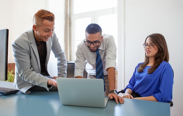 Groep collega&#39;s bij laptop die goed nieuws krijgt