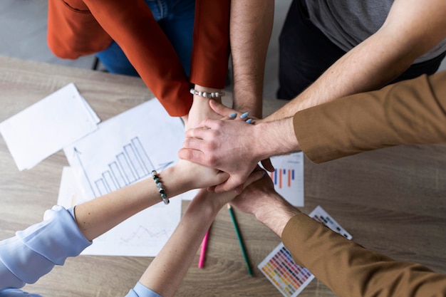 Groep collega's die hun handen in elkaar zetten