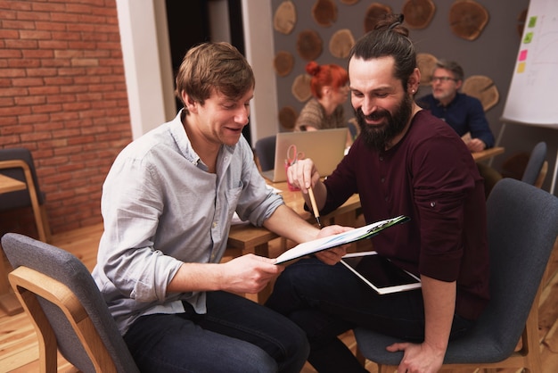 Groep creatieve mensen die het resultaat van werk analyseren